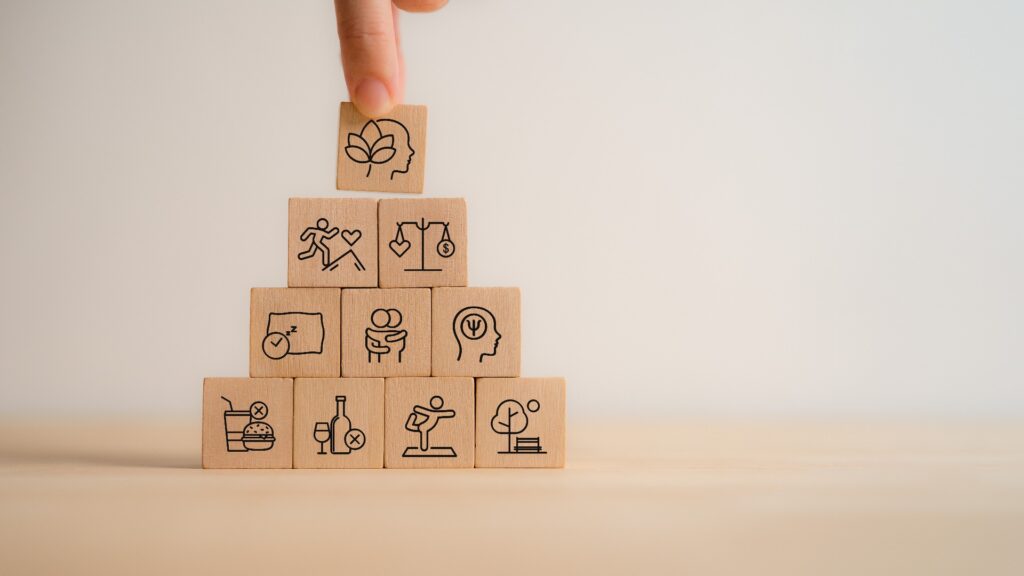Eine Pyramide aus Holzwürfeln symbolisiert einen ganzheitlichen Fitness und Wellness-Ansatz
